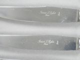three knives that are sitting on a white surface
