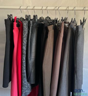 des vêtements suspendus à un portant dans une armoire, sur des cintres