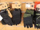 many pairs of gloves hanging on a wall in a store