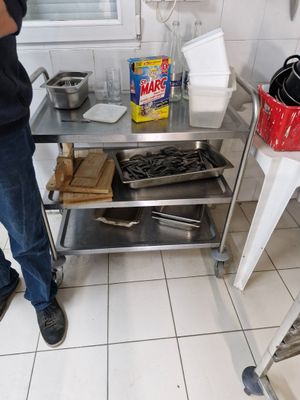 a man that is standing in a kitchen near a table