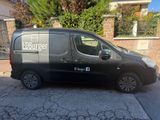 the van is parked on the side of the road in front of a house