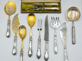beaucoup d'argenterie sur une table, à côté d'une boîte en bois