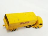 a toy truck that is yellow and has a red sign on it