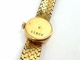 a gold watch that is sitting on a white surface