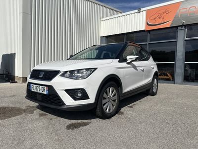 une voiture blanche garée devant un immeuble, devant un immeuble