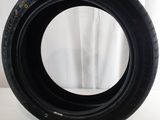 a close up of a tire on a white surface with a white curtain in the background
