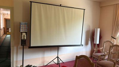un grand écran de projection au milieu d'une pièce