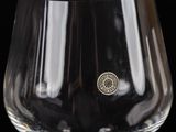 a wine glass that has a gold medallion on it