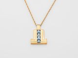 a gold necklace with a blue topaz stone in the center