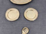 une assiette en argent avec une cuillère et un repose-cuillère posés sur une table