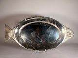 a silver plate with a fish on it on a table