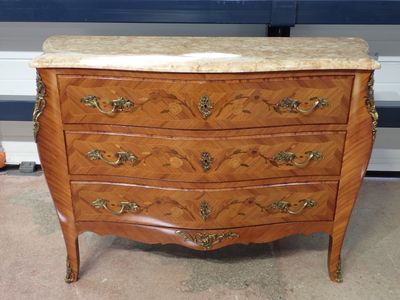 a marble top chest of drawers in the corner of a room