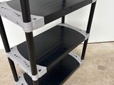 a black and silver shelf with three shelves on top of it