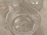 a glass bowl and a glass bottle on a table