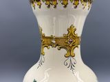 un vase blanc orné d'une bordure dorée