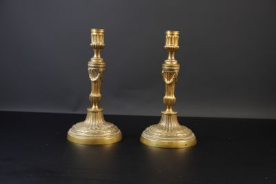 paire de chandeliers anciens en laiton sur table noire