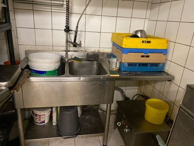 a kitchen with a sink and a counter with buckets on it