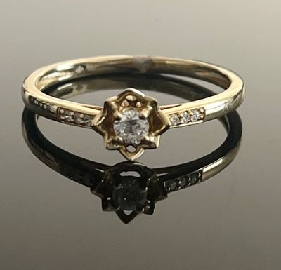 gros plan d'une bague en diamant sur une surface réfléchissante