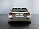 the back of a silver car in a white room with a black floor