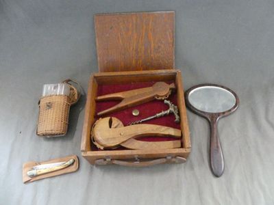 a wooden box with a mirror, a magnifying glass, a pair of scissors, and a mirror in it