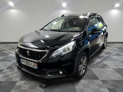 la voiture noire est garée sur un sol en damier dans le garage