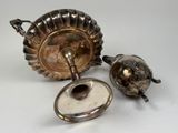a silver teapot and a silver teapot on a white table
