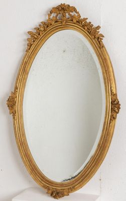 Miroir ovale en bois sculpté et doré à décor de guirlande fl…