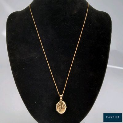un collier en or avec une pièce de monnaie sur le cou d'un mannequin