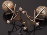pair of antique silver ball earrings on black surface with reflection