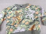the sweater is green and has a tiger and other animals on it