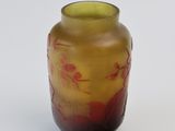a yellow and red vase sitting on a white surface
