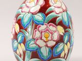 a vase with flowers painted on it sitting on a table