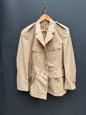 une photo d'une veste beige accrochée à un mur bleu
