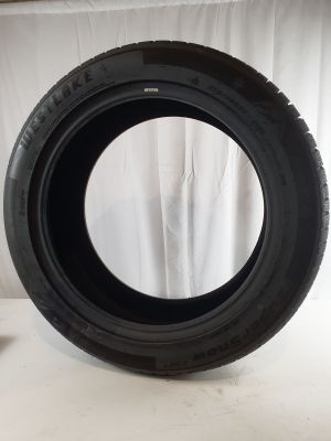 a close up of a tire on a white surface with a white curtain in the background