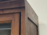 un gros plan d'une armoire en bois avec une porte vitrée