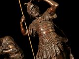 bronze statue of a man with a spear and a dog on a black background