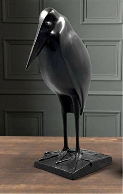 une statue d'oiseau noir posée sur une table en bois