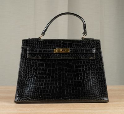 un sac à main en cuir noir posé sur une table en bois