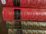 several books are stacked on top of each other on a shelf