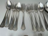 a lot of silver spoons and spoons on the table