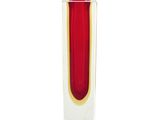 un vase rouge bordé d'or posé sur une surface blanche