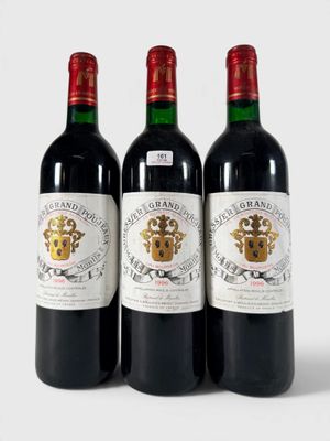 trois bouteilles de vin rouge posées sur une table blanche