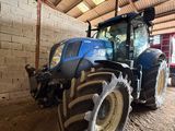 a blue tractor parked inside of a building next to a brick wall