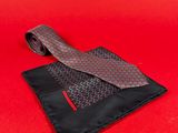 a red and black tie and a black wallet on a red background