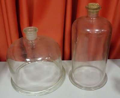 two empty glass bottles sitting on a white table