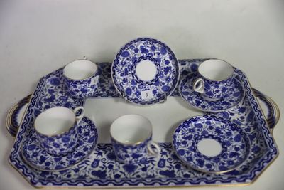 une assiette bleue et blanche sur laquelle sont posées des tasses et des soucoupes