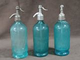 three blue glass bottles with soap dispensers on them