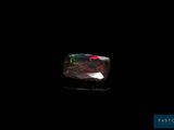 une pierre oplite noire dans laquelle brillent des reflets rouges et verts