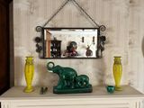 une figurine d'éléphant verte posée sur une commode