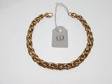 Gros plan sur un bracelet en chaîne en or portant une étiquette